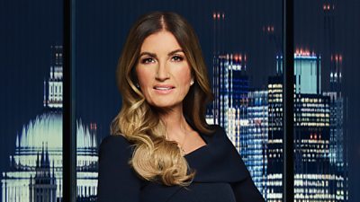 A woman (Karren Brady) in a formal dress stands outside a city backdrop 