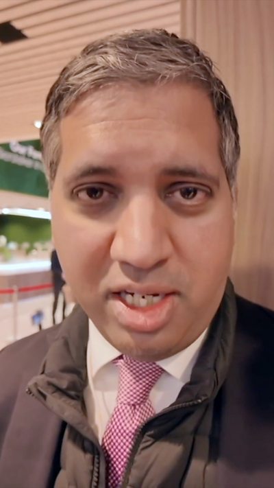 The BBC's Faisal Islam wearing a black suit jacket and a red tie with with dots on it.