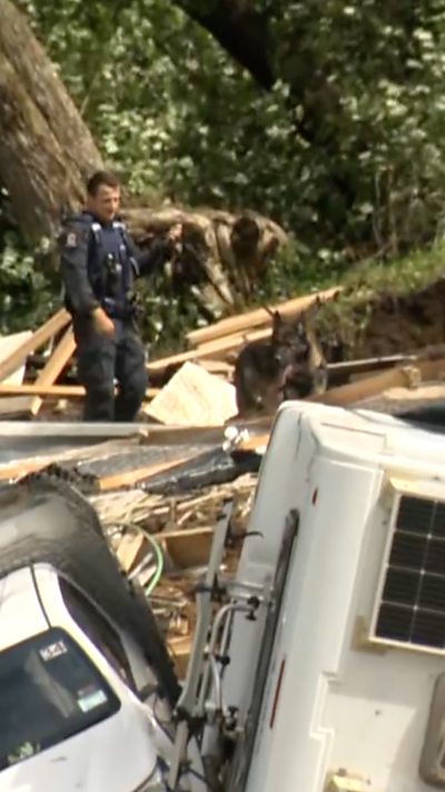 Police officier and police dog searching debris from landslide