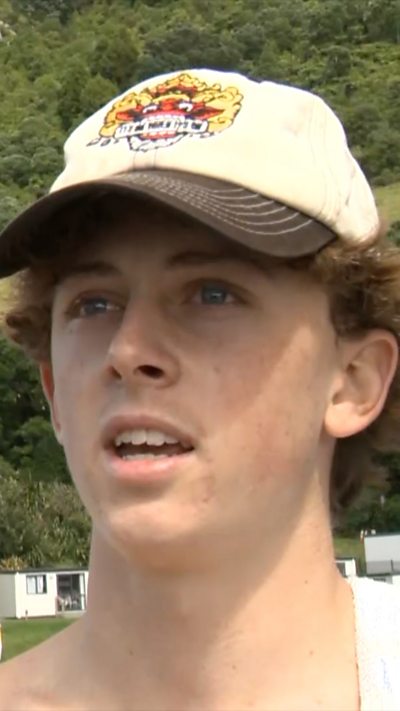 Young man wearing cap standing outside campsite