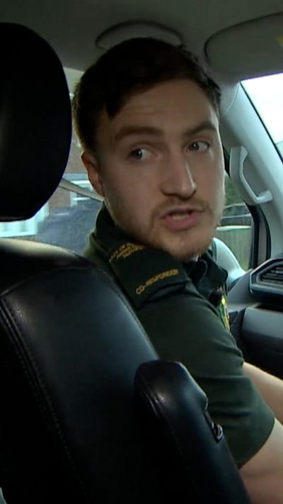 Paramedia in front seat of vehicle looking over his shoulder