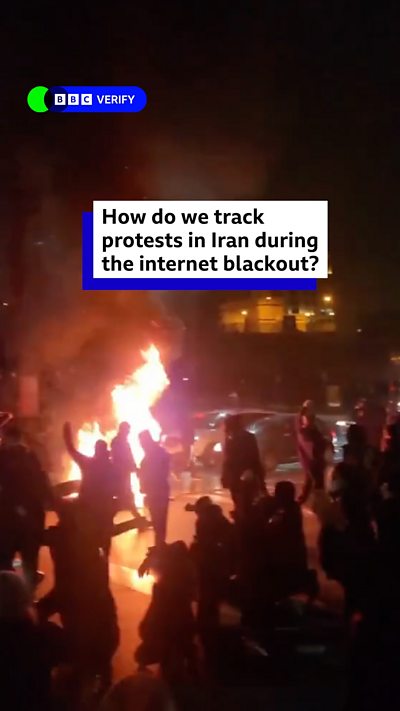 A screengrab of a video showing protestors in Iran around a fire in the street