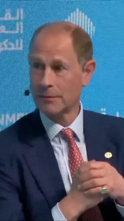 Prince Edward wearing red tie and navy suit speaking