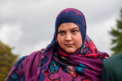 Una mujer (la Sra. El Fassi, interpretada por Fatiha El-Ghorri) mira fijamente a la distancia.