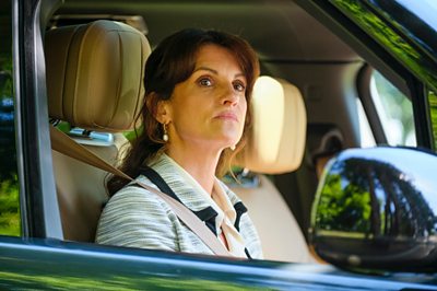 Una mujer (Niky Wardley, que interpreta a Carol en Boarders) está sentada en un automóvil.