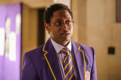 Un joven con uniforme escolar parece nervioso.