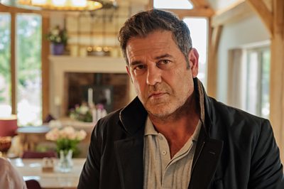 Un hombre (Alfie en Boarders) parece preocupado en un comedor.