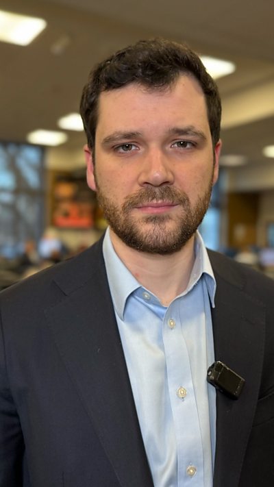 BBC reporter Henry Zeffman wearing blue shirt and navy blazer jacket