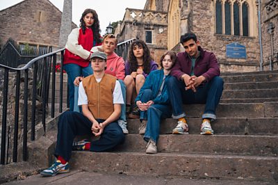 A group of people sit on some church steps.