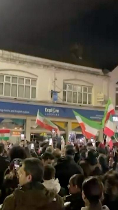 Crowd of people holding Iranian flags on the street in London