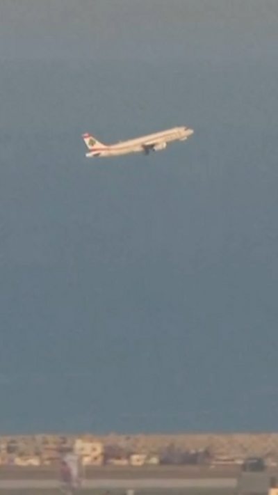 A commercial plane flying in blue skies over Beirut