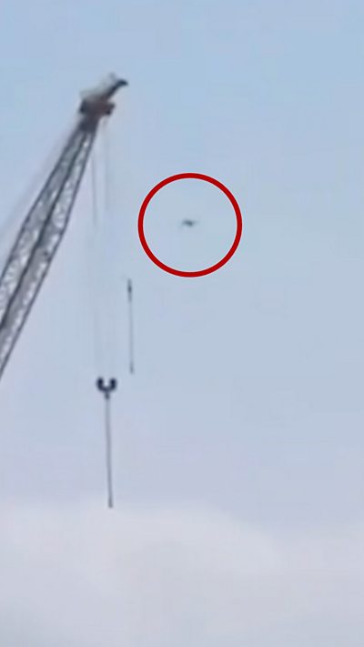 A drone circled in red in the sky