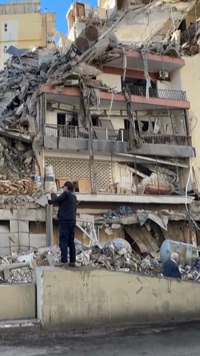 Destroyed building in Beirut with person standing in front of it