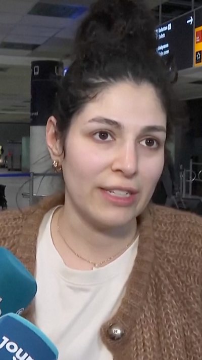 Passenger speaking to journalists from airport