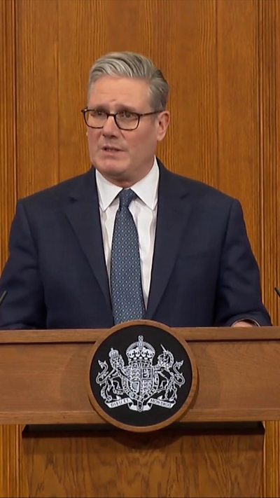 Starmer speaking at lectern during press conference