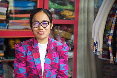 Pictiure of Yam Kumari Tumsa in her factory wearing a jacket she has made