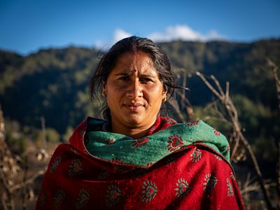 Sunita Bohora looking directly into camera wearing traditional dress in rural Nepal 
