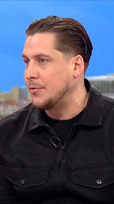 Man wearing black t-shirt and black denim jacket