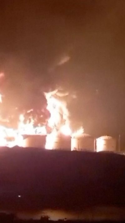 Four tanks visible amid an explosion during the night
