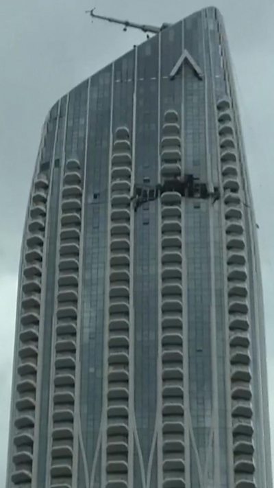 A glossy high-rise building with a hole across part of one floor