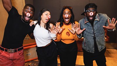 Photo of the four members of The Creator Band wearing red noses. Each nose has a different letter, spelling out: 'Busk'.