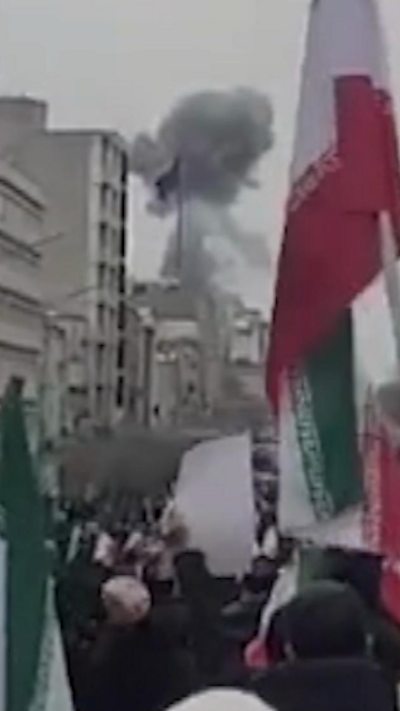 Cuộc biểu tình ở Tehran với cột khói khổng lồ phía sau.