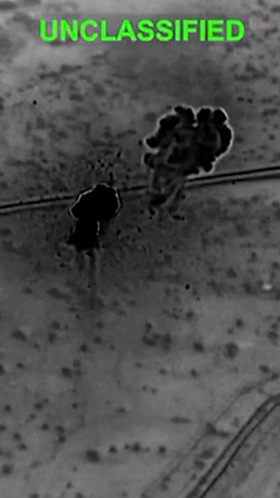 A black and white shot of strikes on a bare landscape with the word Unclassified in green above.