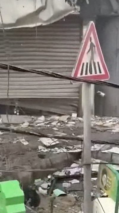 Rubble a Beirut street with a pedestrian crossing visable