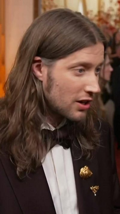 Ludwig Goransson speaks at the oscars red carpet.