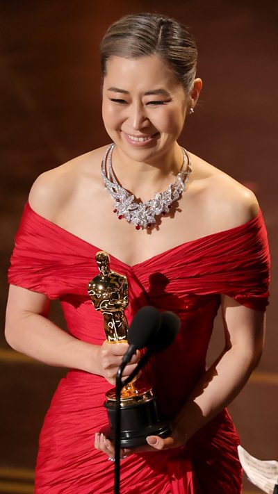 Maggie Kang accepts the Animated Feature Film for "KPop Demon Hunters" onstage.