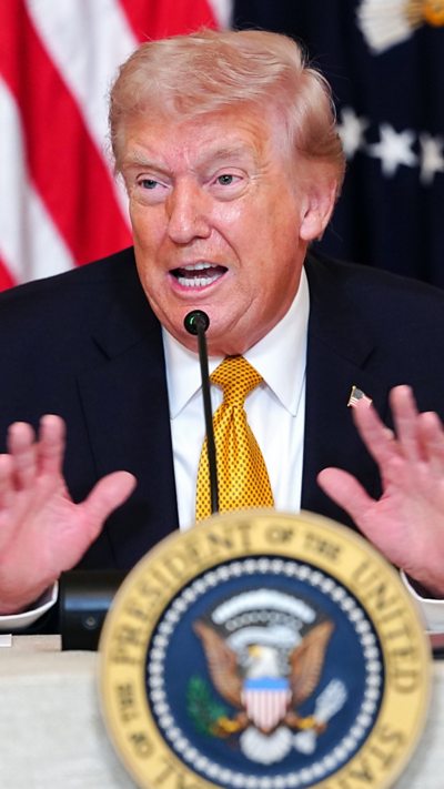 Trump gesticulates at a presser.