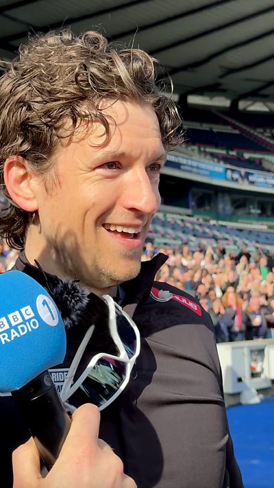 Greg James smiles as he's interviewed at the finish line.