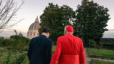 Harry and Cardinal Roche walk side-by-side in the Vatican gardens.