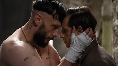 Ruben (Richard Gadd) and Niall (Jamie Bell) in a scene from Half Man. Ruben is topless and has his hands wrapped for boxing. The two men lean their foreheads against each other.