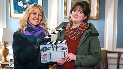 Behind-the-scenes photo of Ashley Jensen and Alison O’Donnell holding a clapperboard for Shetland series 11. 