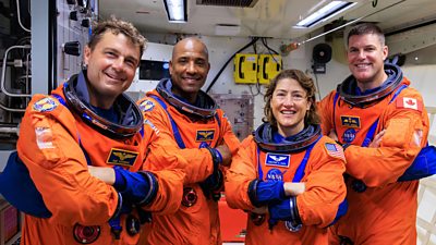 Photo of four astronauts in space suits. 