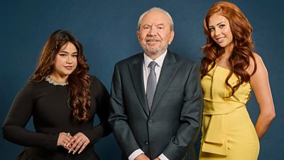 Lord Sugar stands smiling, flanked on either side by his Apprentice finalists
