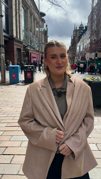 Woman with blonde hair in sparkly blazer