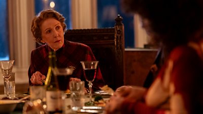 Patricia Hodge as Miriam Crace and Yasmine Al Massri as Leilah Crace. The pair sit at a grand dinner table. 