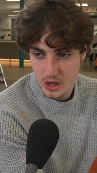 A teenager speaking into a microphone