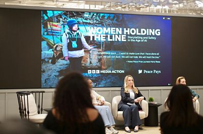 Arbana Xharra (centre) and Fatou Baldeh (left) on stage at the Women Holding the Line event