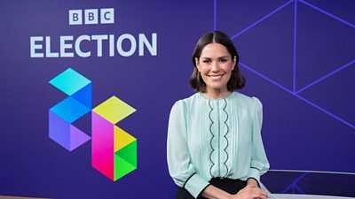 Rebecca Curran wearing a light blue top and smiling at the camera, behind here are the words BBC election 26