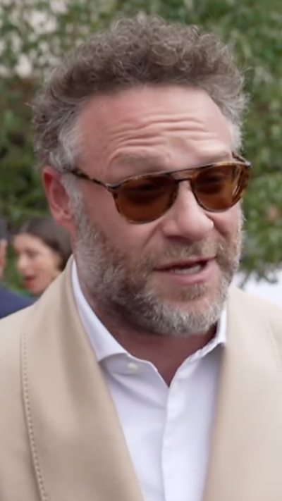 Close-up of Seth Rogen wearing beige suit and white shift on the red carpet