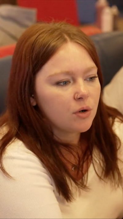 A woman with light brown hair sitting down