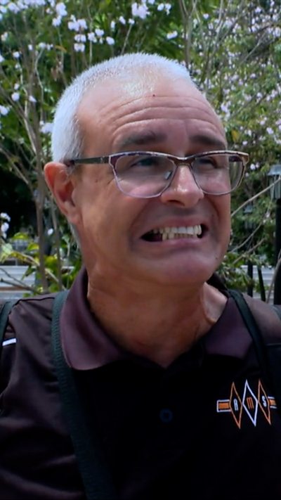 A man in a purple polo shirt grimacing