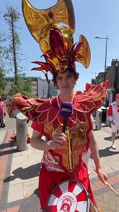 Man wears a red and gold samba costume
