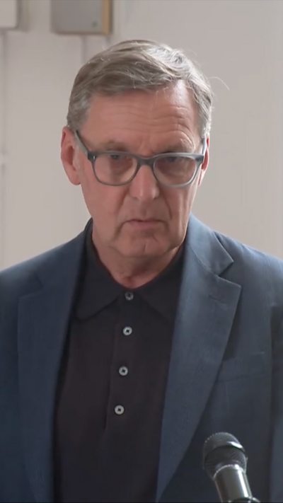 Alan Milburn in a dark suit and glasses