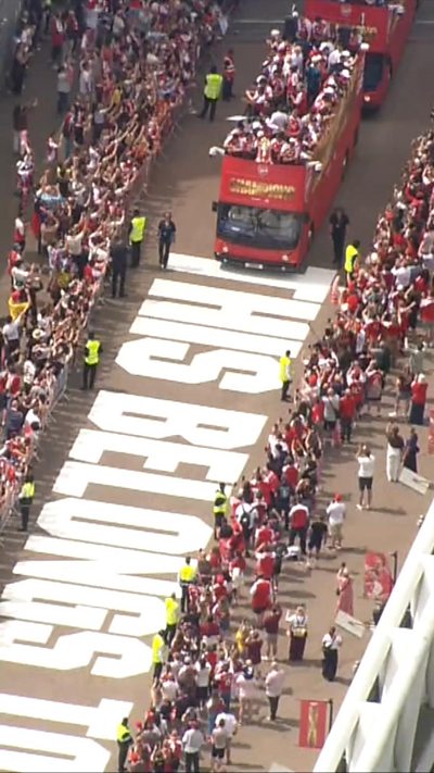 A bus carrying players is seen driving along a bridge