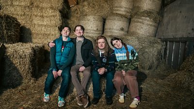 Jordan, Callum, Lorcan, Gemma sit on hay in a shed