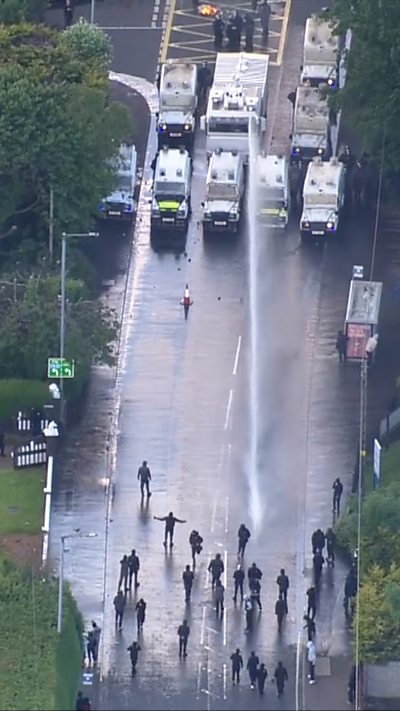 Protesters being sprayed with water canon.